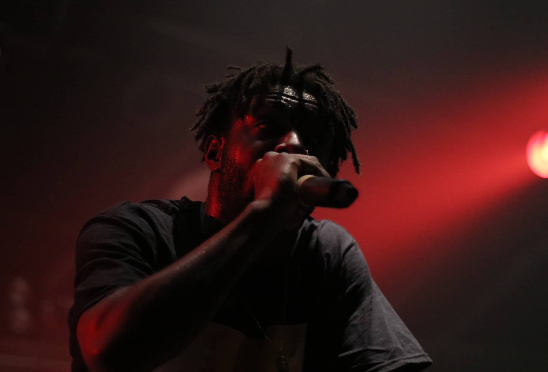 Rapper performing live with red background